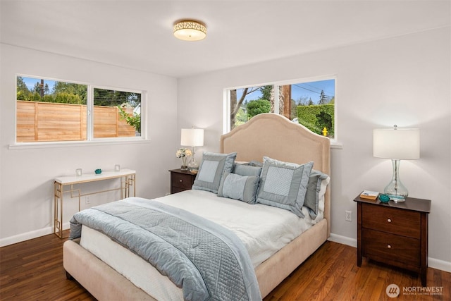 bedroom with multiple windows, baseboards, and wood finished floors