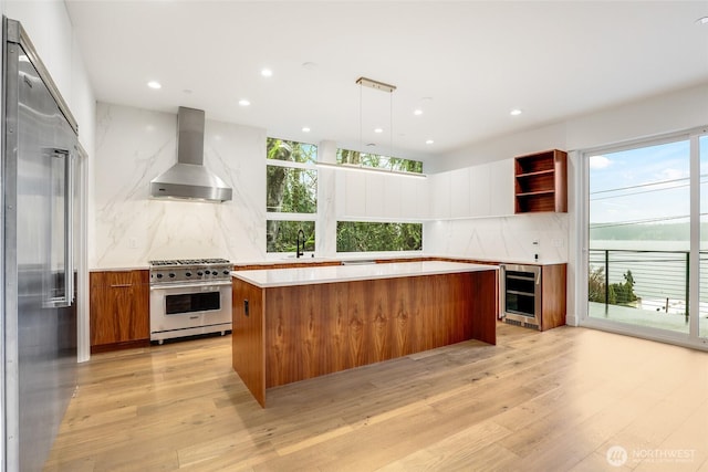 kitchen featuring wine cooler, high quality appliances, wall chimney exhaust hood, and modern cabinets