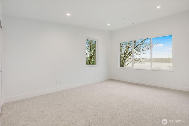 unfurnished room featuring recessed lighting, a healthy amount of sunlight, light colored carpet, and baseboards