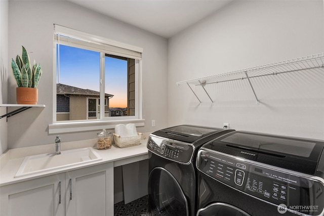 laundry room featuring cabinet space, separate washer and dryer, and a sink