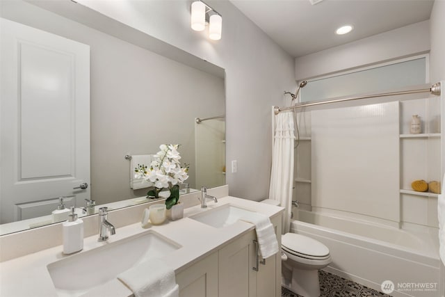 full bath featuring double vanity, toilet, shower / bath combo with shower curtain, and a sink