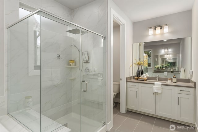 full bath featuring vanity, toilet, a shower stall, and tile patterned flooring