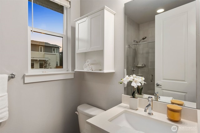 bathroom featuring toilet, a stall shower, and vanity