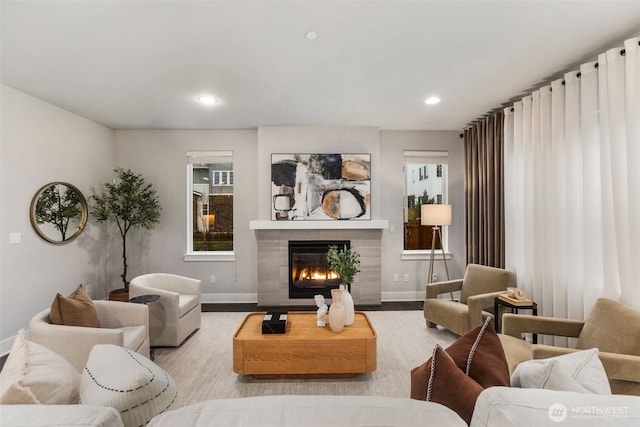 living area with recessed lighting, baseboards, wood finished floors, and a tile fireplace