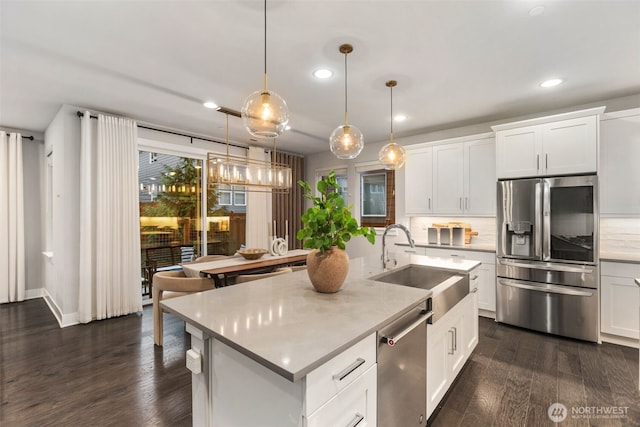 kitchen featuring a sink, dark wood-type flooring, appliances with stainless steel finishes, and light countertops