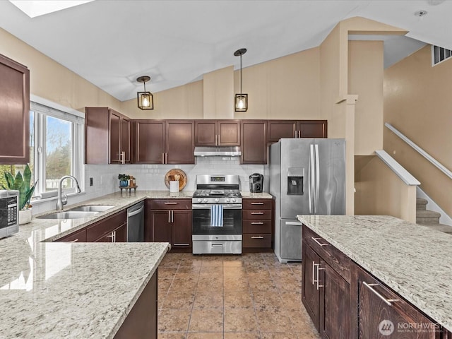 kitchen with light stone countertops, a sink, under cabinet range hood, appliances with stainless steel finishes, and backsplash