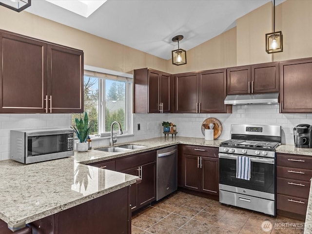 kitchen featuring a sink, under cabinet range hood, vaulted ceiling with skylight, appliances with stainless steel finishes, and decorative backsplash