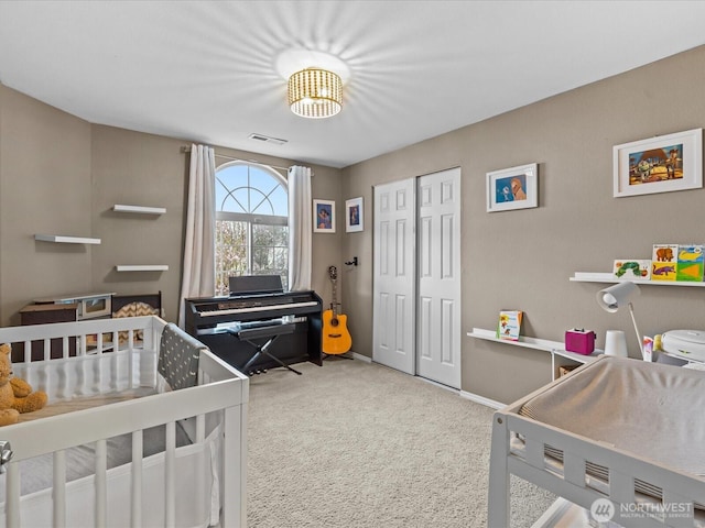 carpeted bedroom with a closet, visible vents, and baseboards