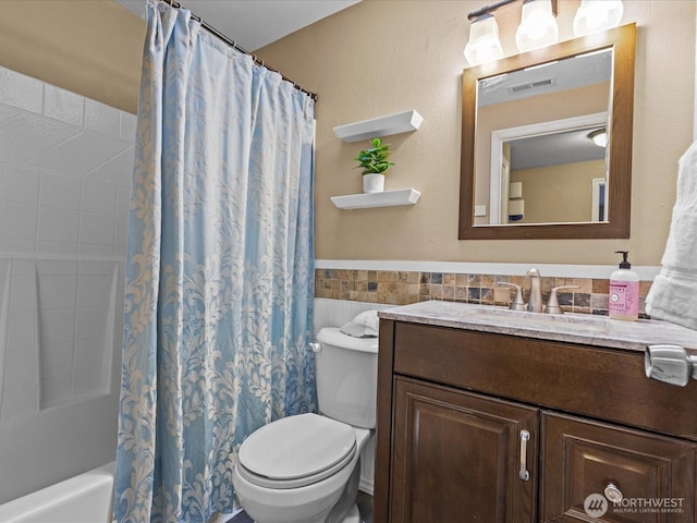 full bath featuring visible vents, tile walls, toilet, shower / tub combo, and vanity