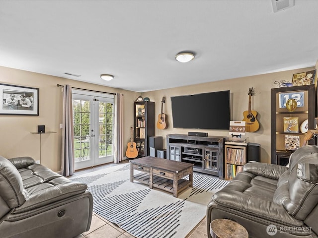 living area with light tile patterned floors, visible vents, and french doors