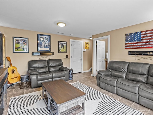 living area with tile patterned floors, visible vents, and baseboards