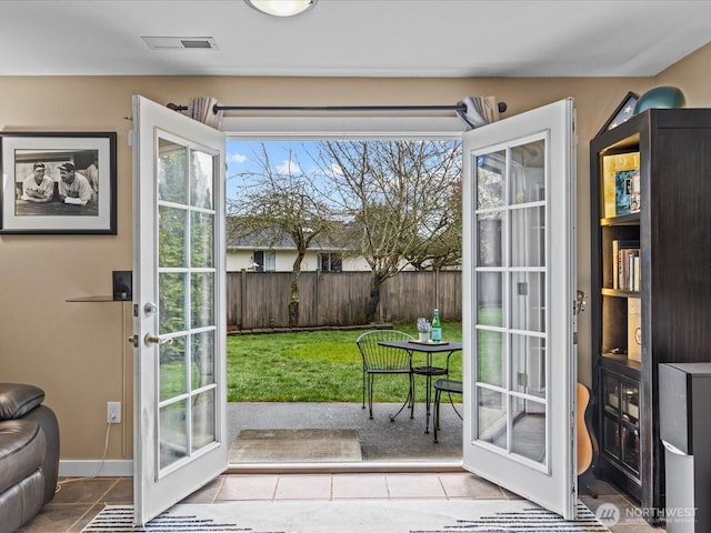 doorway featuring tile patterned floors, visible vents, and baseboards