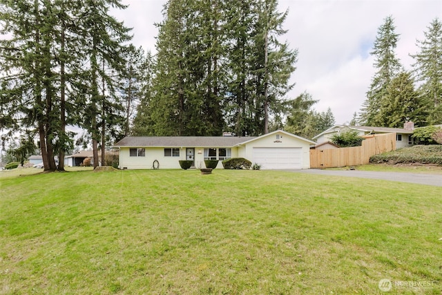 ranch-style home featuring aphalt driveway, an attached garage, and a front lawn