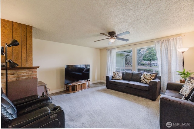 living room with light colored carpet, a textured ceiling, baseboards, and ceiling fan