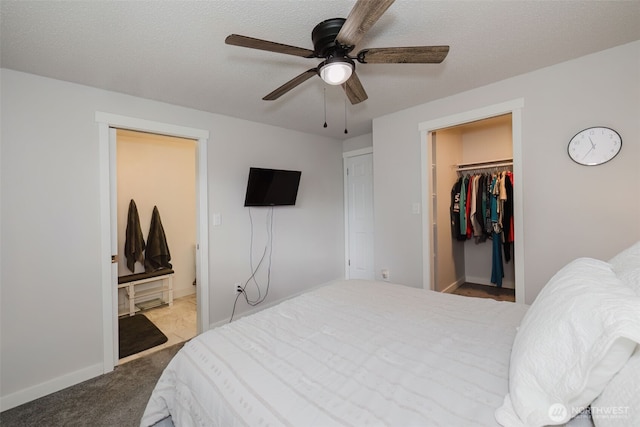 bedroom featuring a walk in closet, a textured ceiling, a closet, carpet floors, and connected bathroom