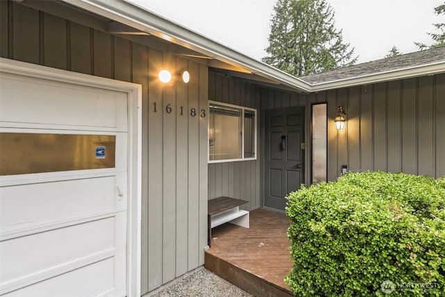 entrance to property with board and batten siding and an attached garage