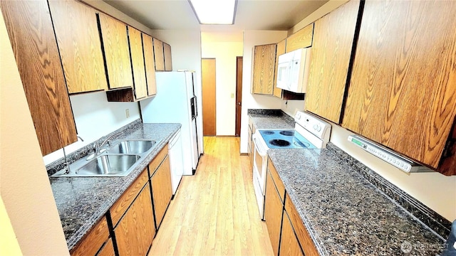 kitchen featuring white appliances, light wood-style flooring, baseboards, and a sink