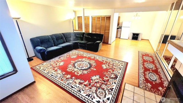 living area featuring a notable chandelier and light wood-type flooring