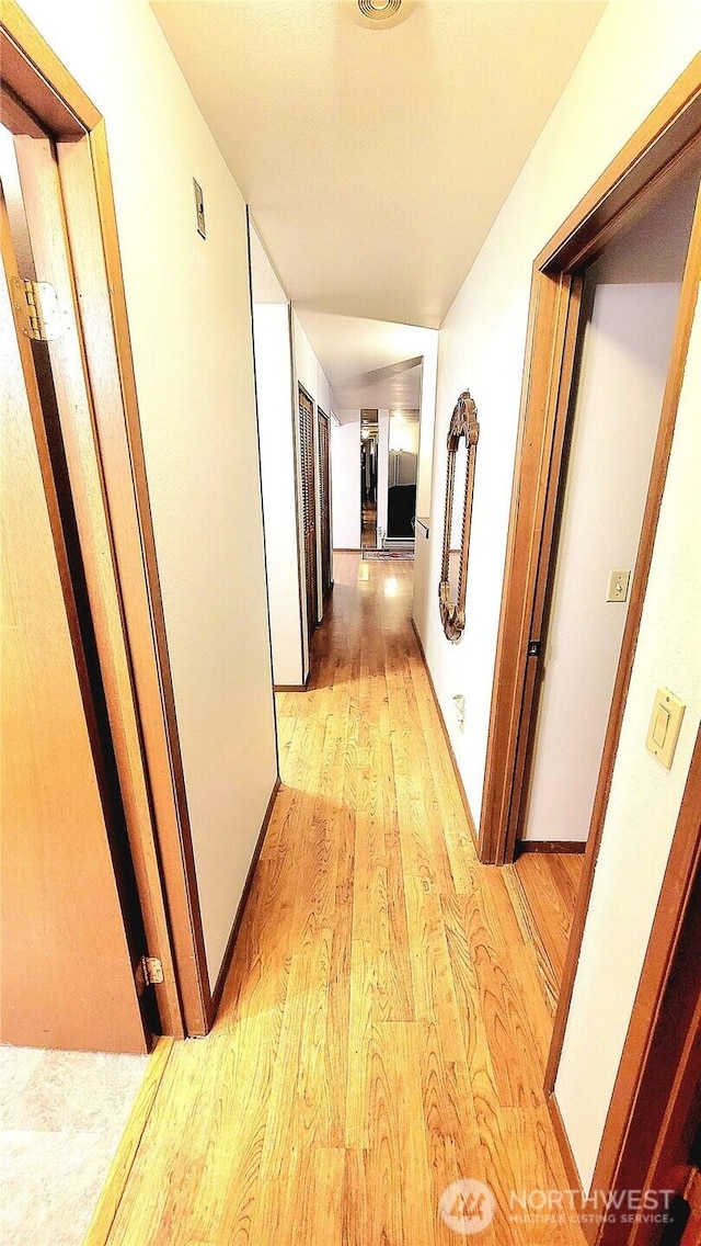 corridor with light wood-style floors and visible vents