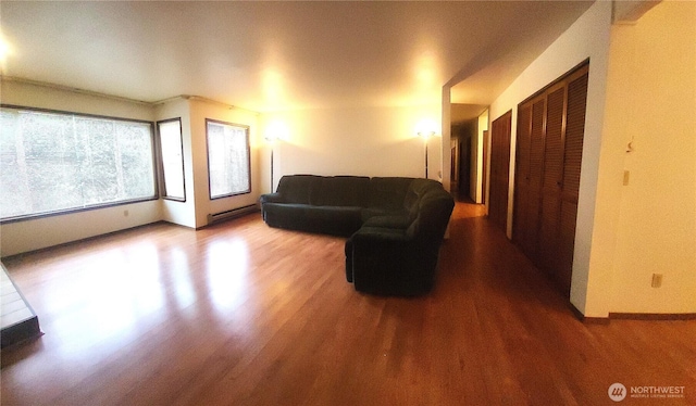 living area featuring a baseboard radiator and wood finished floors