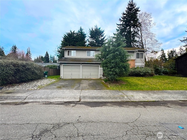 view of front facade with aphalt driveway, a front lawn, a garage, and fence