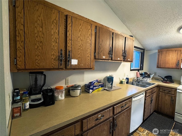 kitchen featuring a sink, white appliances, a textured ceiling, and light countertops