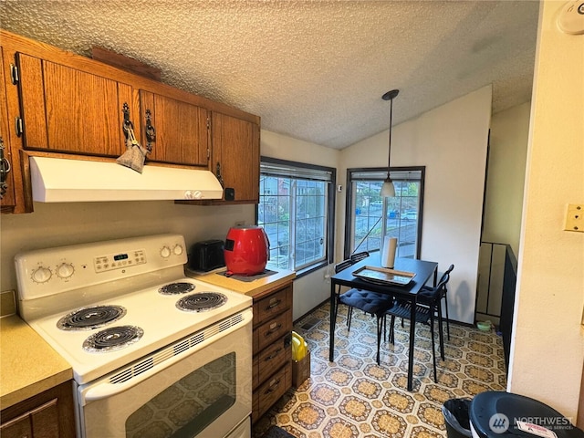 kitchen featuring light countertops, vaulted ceiling, brown cabinets, electric stove, and exhaust hood