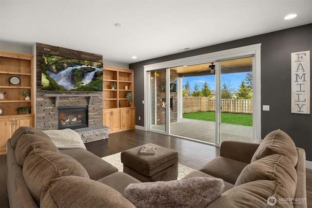 living room featuring recessed lighting, baseboards, dark wood-style floors, and a fireplace