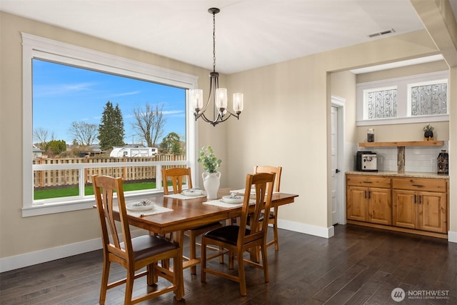 dining room with visible vents, baseboards, a notable chandelier, and dark wood-style flooring