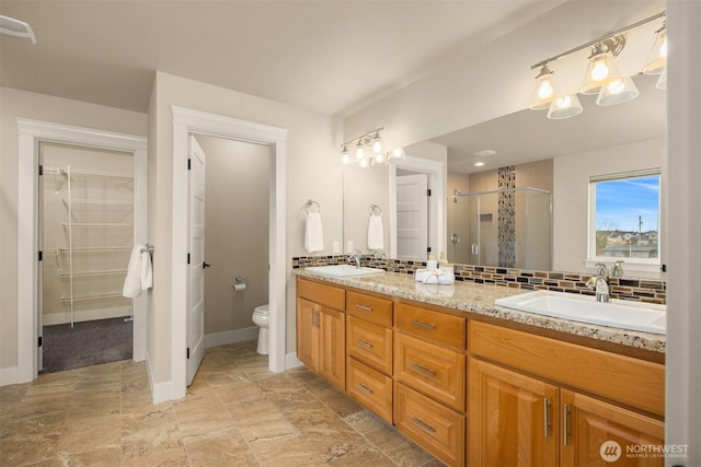 full bath with a shower stall, toilet, tasteful backsplash, and a sink