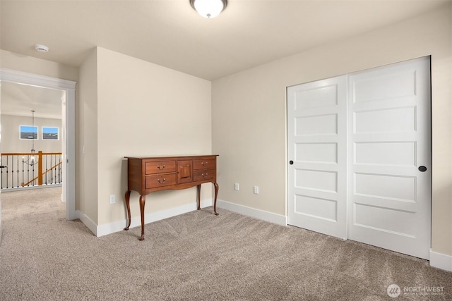 carpeted bedroom featuring baseboards and a closet