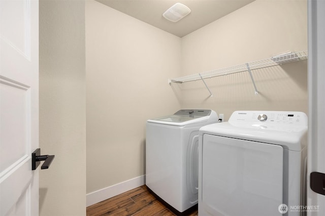 laundry area featuring laundry area, dark wood-style floors, baseboards, and washing machine and clothes dryer