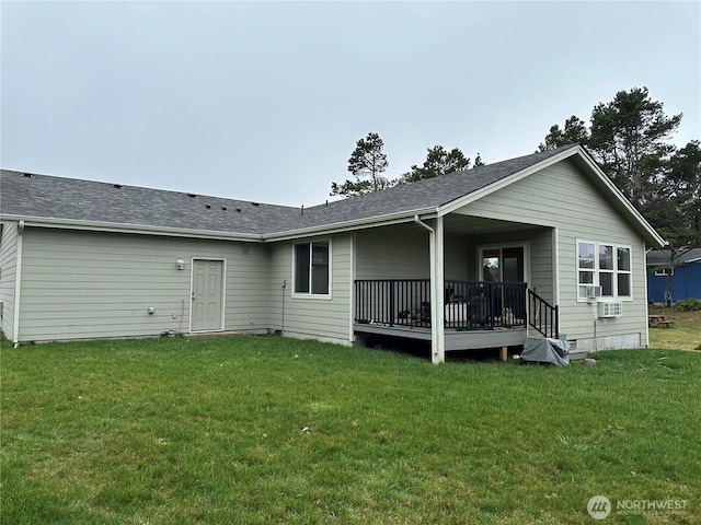 back of property with a lawn and a shingled roof