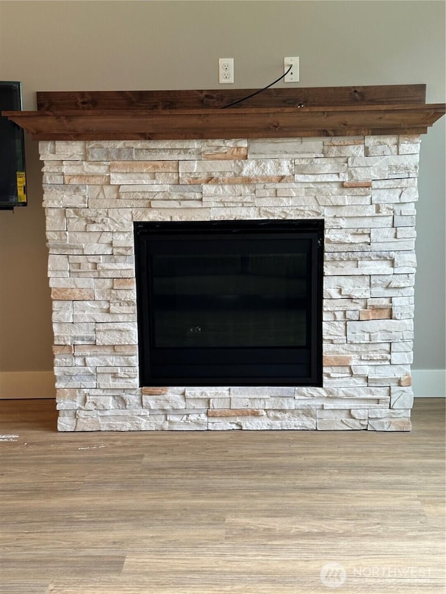 details featuring a fireplace and wood finished floors