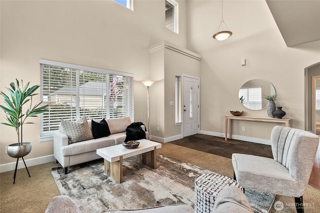 living area featuring arched walkways, baseboards, and a towering ceiling