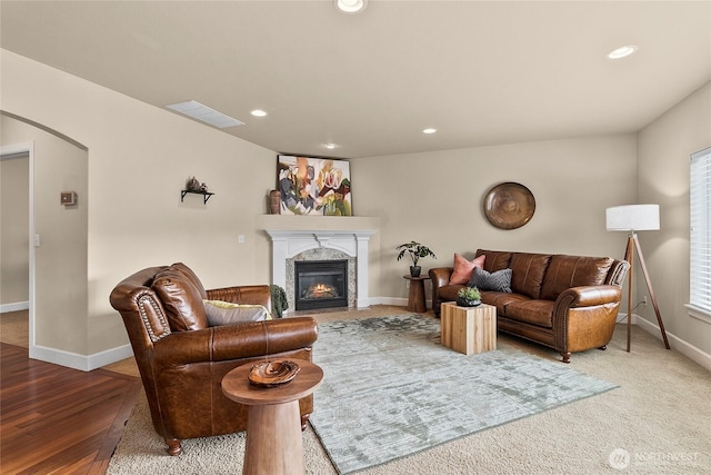 living area with visible vents, recessed lighting, a fireplace, and arched walkways