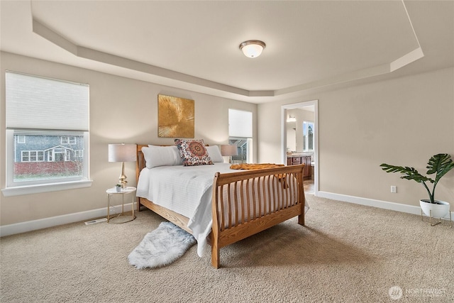 bedroom with baseboards, carpet, and a tray ceiling