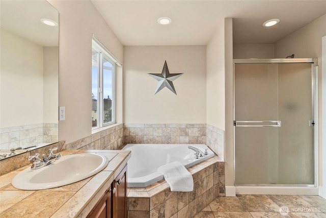 full bathroom featuring vanity, a shower stall, a bath, and recessed lighting