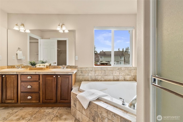 bathroom with a sink, a bath, double vanity, and tile patterned floors