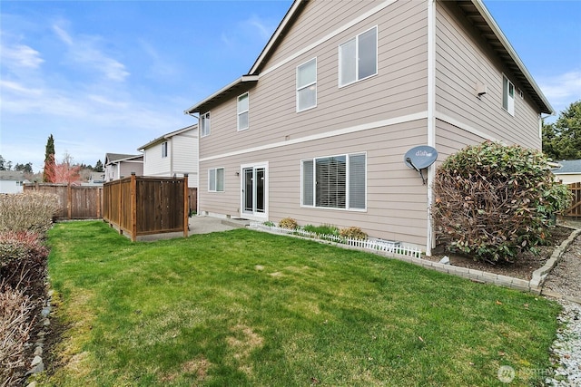 rear view of property with a fenced backyard, a patio, and a yard