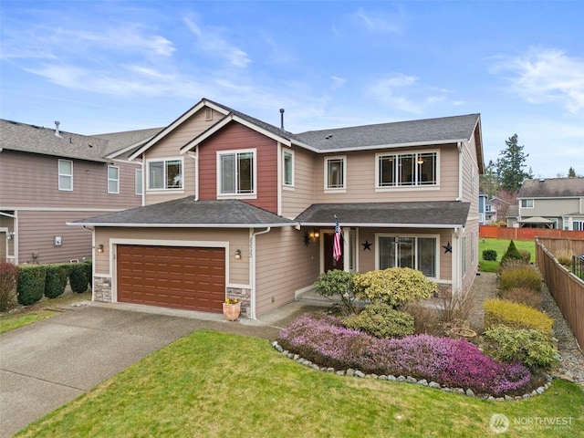 view of front of house with aphalt driveway, stone siding, fence, a front yard, and an attached garage