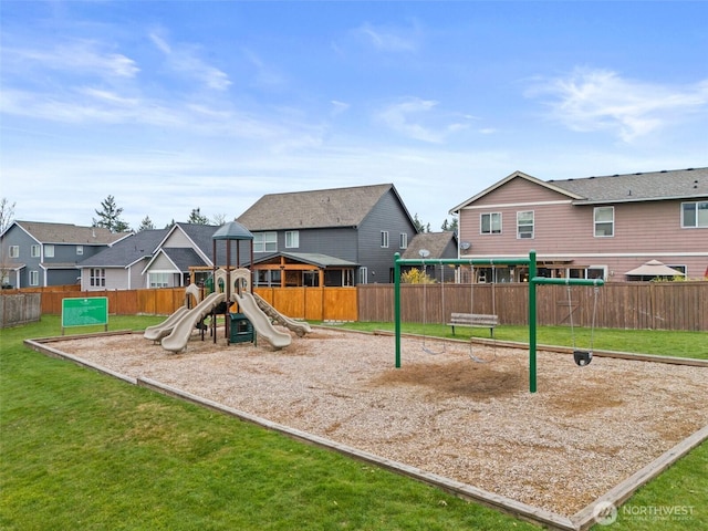 view of jungle gym featuring a yard, fence, and a residential view