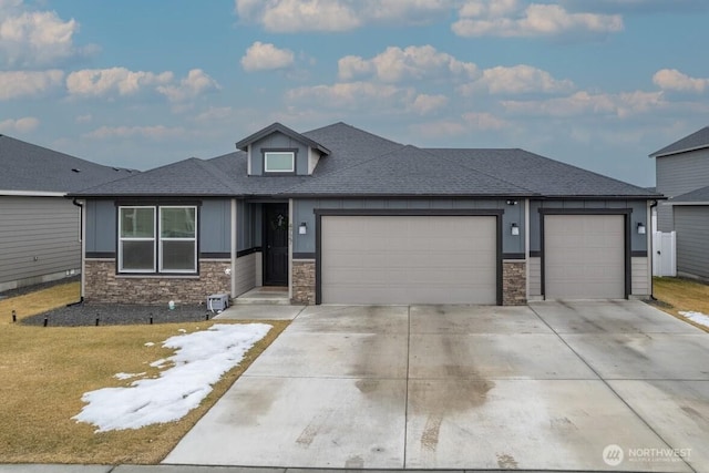 prairie-style home with driveway, a front yard, a garage, and board and batten siding