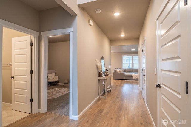 corridor featuring recessed lighting, light wood-type flooring, and baseboards