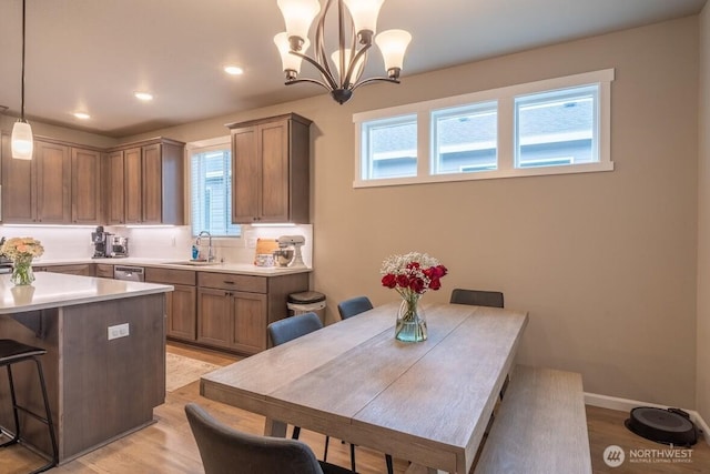 dining space with recessed lighting, light wood-type flooring, baseboards, and an inviting chandelier