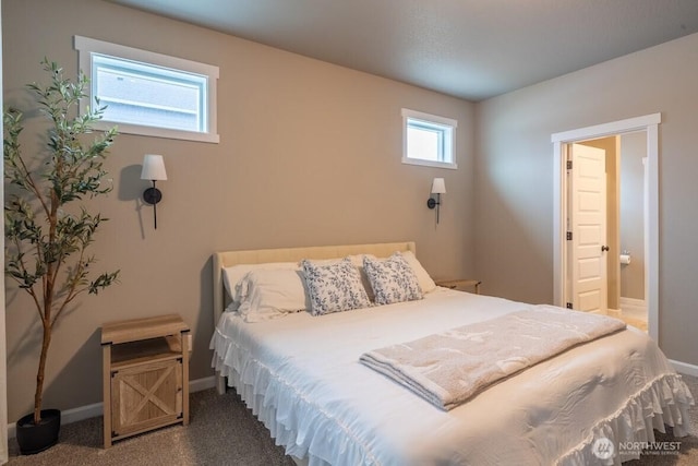 carpeted bedroom featuring baseboards and ensuite bath