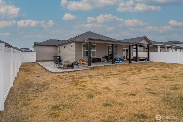 back of property with a patio, a yard, and a fenced backyard