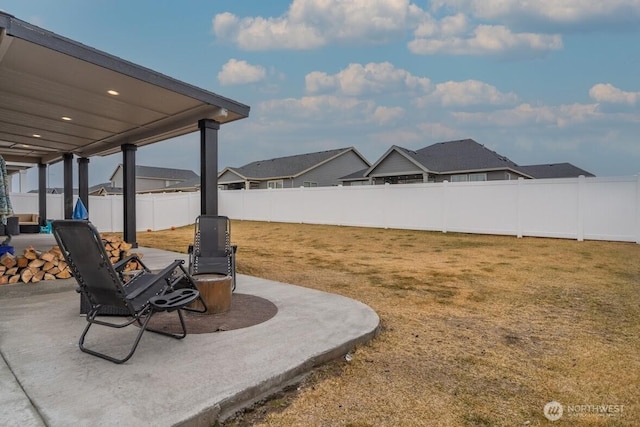 view of yard featuring a patio area, a residential view, and a fenced backyard