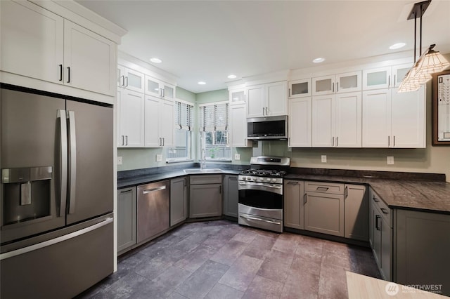 kitchen with a sink, dark countertops, white cabinetry, recessed lighting, and stainless steel appliances