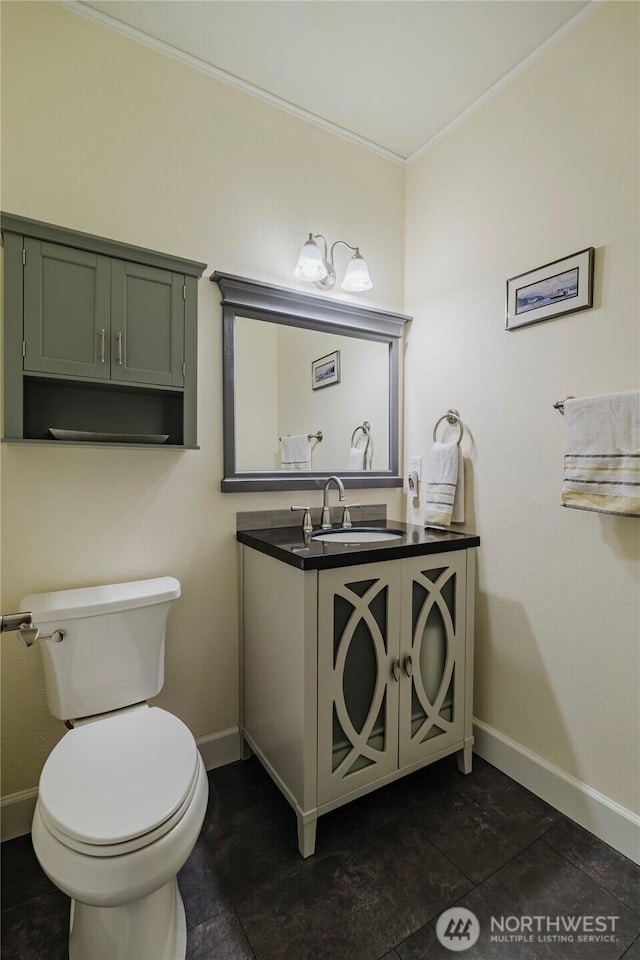 bathroom featuring baseboards, toilet, vanity, and crown molding